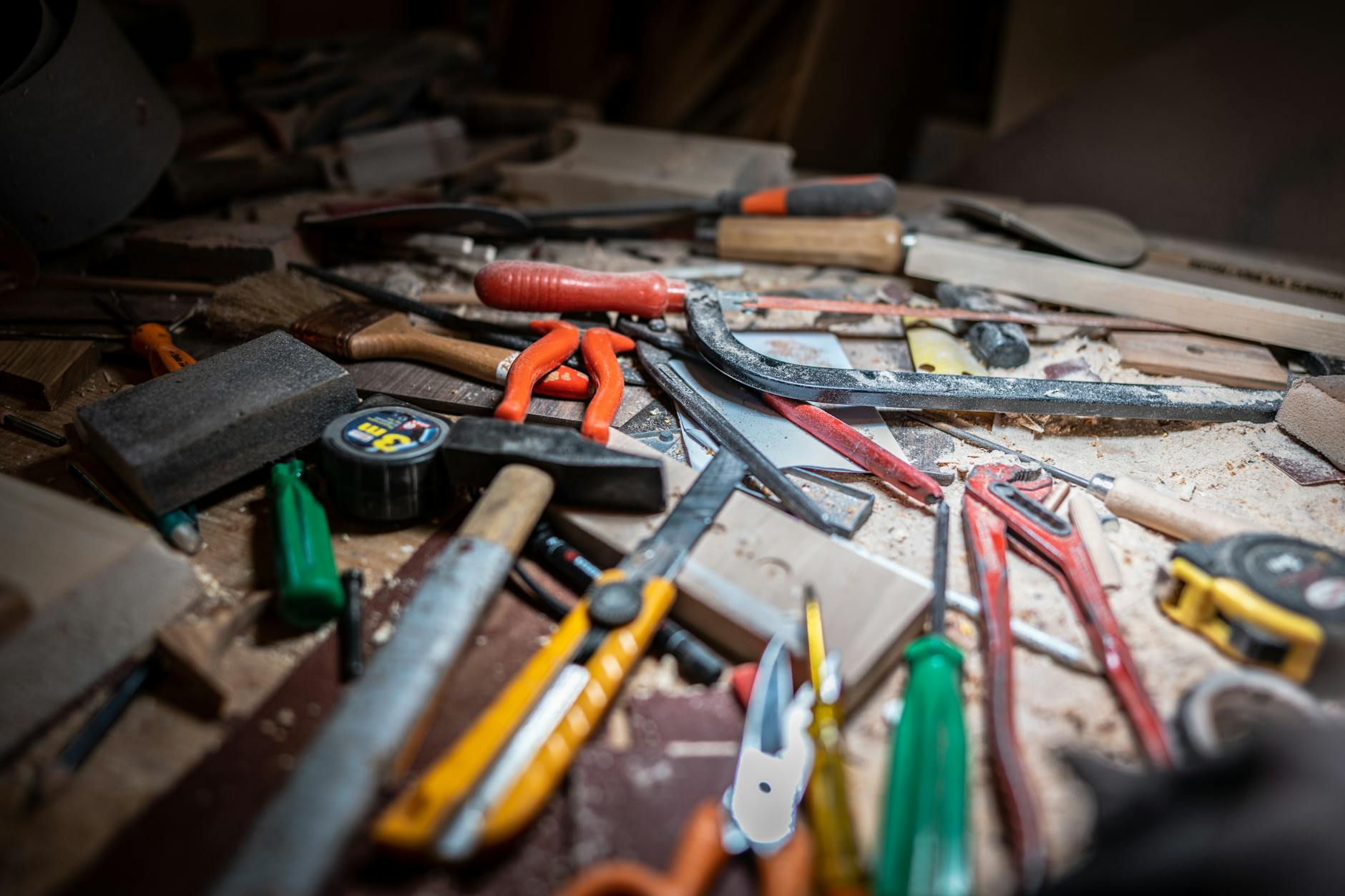 Close-up of a cluttered workbench with various carpentry tools and equipment.